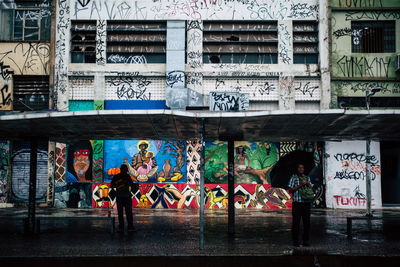 People against graffiti wall in city