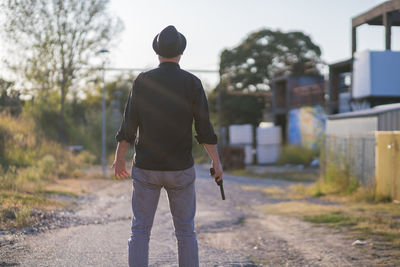 Rear view of man walking on footpath