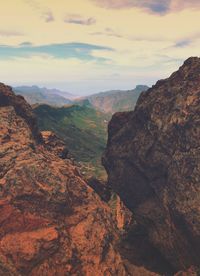 Scenic view of mountains against cloudy sky