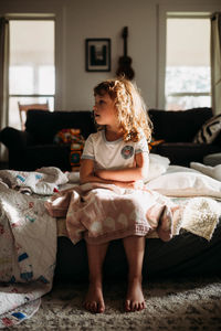 Young girl sitting on air up mattress in living room