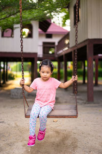 Girl sitting on swing at playground