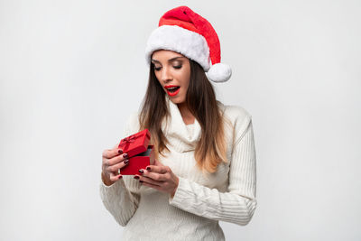 Young woman wearing hat while standing against white background