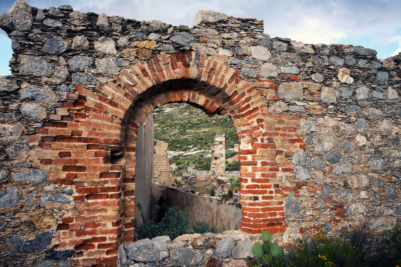 VIEW OF OLD BRICK WALL AGAINST STONE WALLS