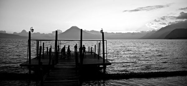 Wooden jetty in sea against sky