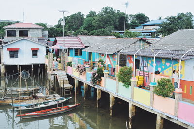 Houses in canal amidst buildings in city