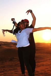 Couple enjoying in desert during sunset