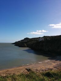 Scenic view of beach against blue sky