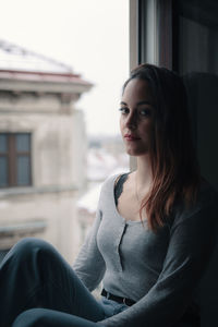 Portrait of smiling young woman sitting outdoors