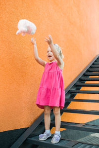 Full length of woman standing against wall