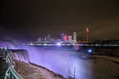 Distant view of illuminated city seen from observation point at night