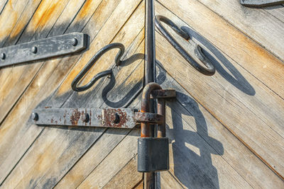 Vintage wooden gate with rusty old padlock closeup