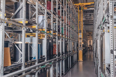 Forklift lift at plant. colored cable wound on spools. metal shelves with colored spools of cable 