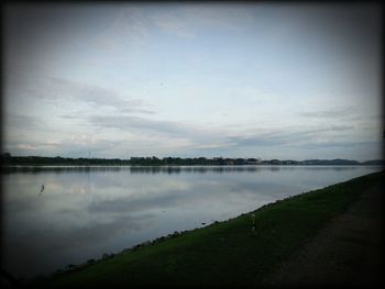 Scenic view of lake against cloudy sky