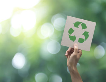 Cropped hand holding recycling symbol