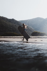 Side view of man surfing on mountain against sky