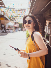 Side view of woman holding map while standing outdoors