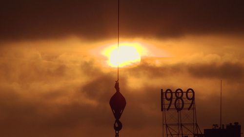 Silhouette lamp against sky during sunset