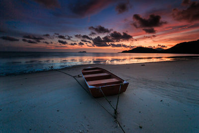 Lifeguard hut on beach against sky during sunset