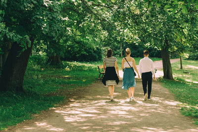 Rear view of women walking on footpath