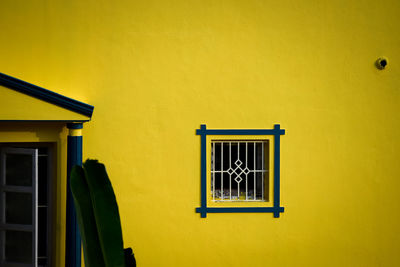 Close-up of yellow window on wall of building