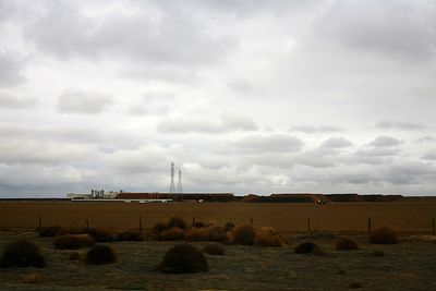 Scenic view of field against cloudy sky