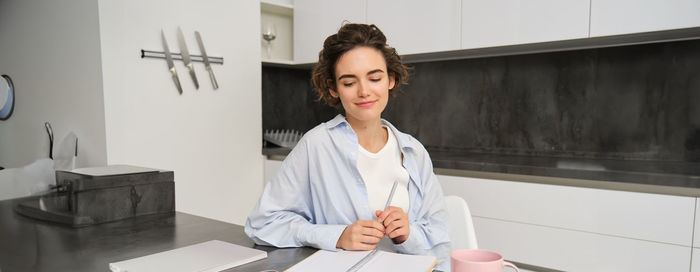 Portrait of young woman standing in office