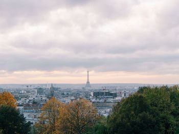 View of cityscape against cloudy sky