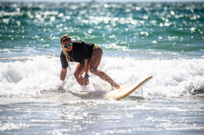 Full length of man splashing water in sea