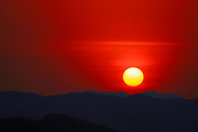 Scenic view of silhouette mountains against romantic sky at sunset