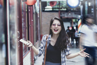 Portrait of smiling young woman standing outdoors