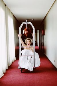 Portrait of two girls playing in a cart in a hall of a hotel 