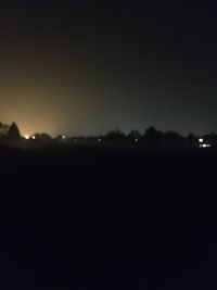 Defocused image of illuminated city against clear sky at night