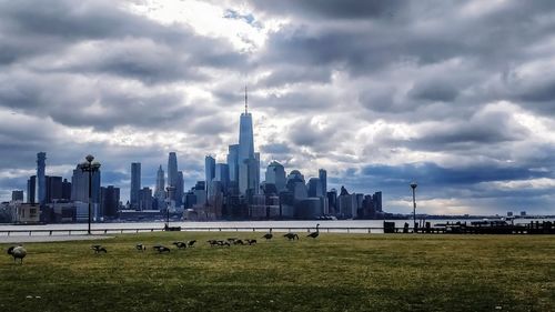 Modern buildings in city against cloudy sky