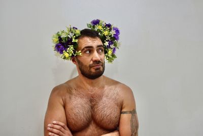 Portrait of shirtless man against wall