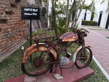 Bicycle parked on wall by street