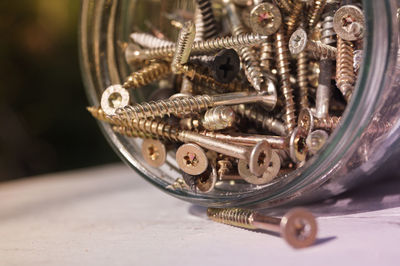 Close-up of screws in jar on table