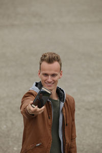 Young man taking selfie through mobile phone