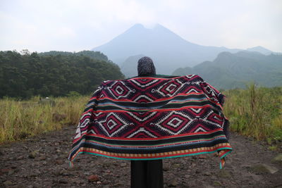 Rear view of woman with scarf standing on land