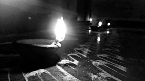 Close-up of lit candle on floor