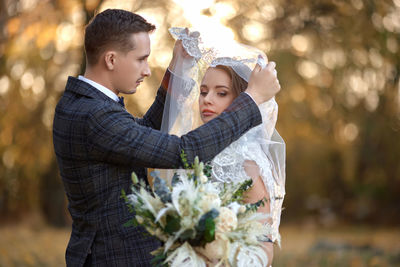 Side view of bride holding bouquet