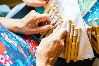 Midsection of woman holding thread spools