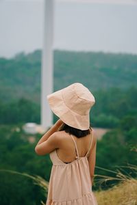 Rear view of woman wearing hat standing outdoors