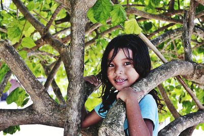 Portrait of cute girl smiling by tree