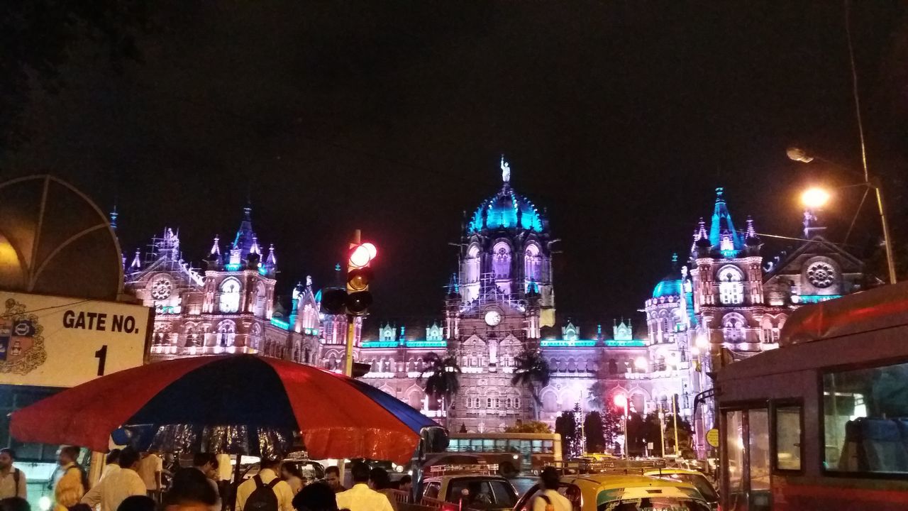 CROWD AT ILLUMINATED CHRISTMAS TREE AT NIGHT