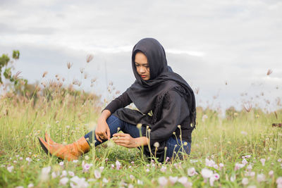 Full length of woman sitting on field