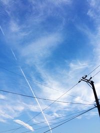 Low angle view of electricity pylon against blue sky