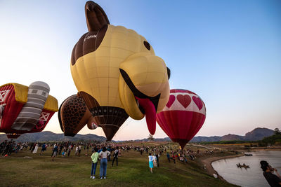 Group of people on hot air balloon against sky