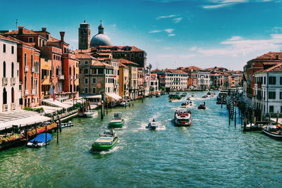 Boats in canal amidst buildings in city