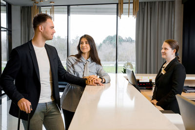 Hotel receptionist checking couple in