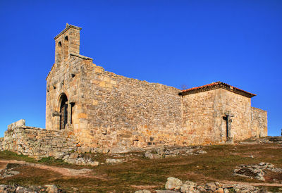 Low angle view of old building against blue sky